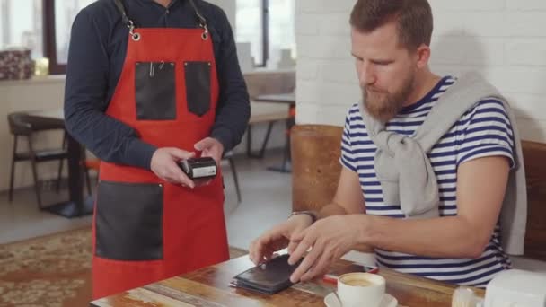 Mann bezahlt Frühstück im Café. — Stockvideo