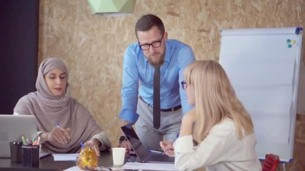 Dos mujeres multiétnicas están debatiendo con el director masculino en el cargo — Vídeo de stock