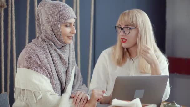 Två kvinnliga vänner chattar i Café och tittar på visning av laptop — Stockvideo