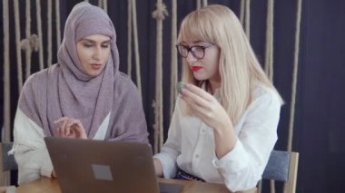 İki arkadaş kadın odada laptop ekranında bakıyor ve tartışmak