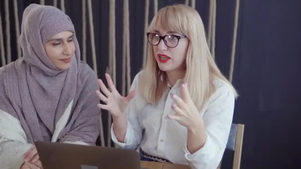 Twee vrouwen bespreken werkproject kijken in notebook in Office — Stockvideo