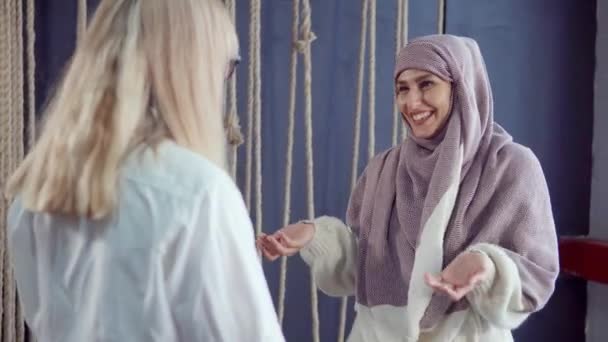 Μουσουλμάνοι και δυτικοί φίλοι συναντιάζονται στο καφέ, αγκαλιάζοντας και αγαλλίαση — Αρχείο Βίντεο