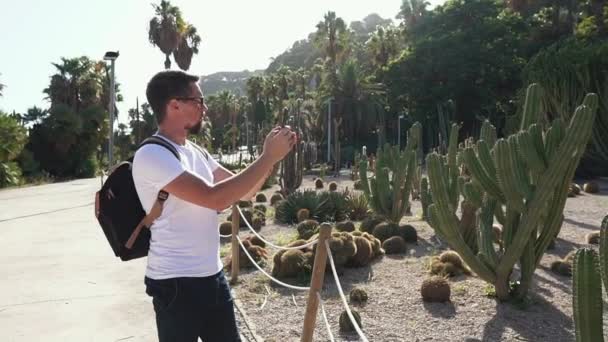 Турист фотографирует в парке на смартфоне . — стоковое видео
