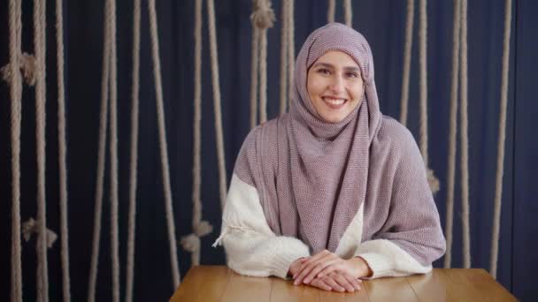 Adulto hermosa mujer musulmana con hijab en la cabeza sonriendo para la cámara en la habitación — Vídeos de Stock