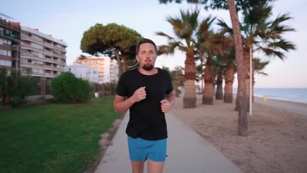 Uomo sicuro di sé che corre sulla spiaggia . — Video Stock