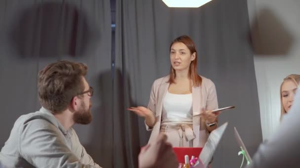 Веселая женщина отвечает на вопросы своих коллег во время своего выступления — стоковое видео
