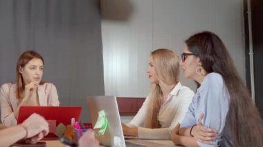 Üç kadın ofiste iş toplantısında birbirleri ile tartışıyor