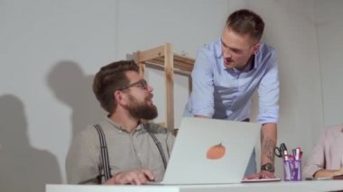İki adam çalışma gününde ofiste iletişim, bir laptop oturuyor