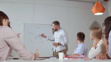 Erkek yönetici brifing iş ortaklarına grafik sunuyor,