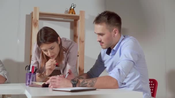L'homme et la femme grondent est la salle de bureau, vérifiant le plan des travaux — Video