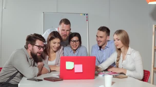 Grupo de jóvenes trabajadores oficiales están viendo videos divertidos en el portátil, caras sonrientes — Vídeo de stock