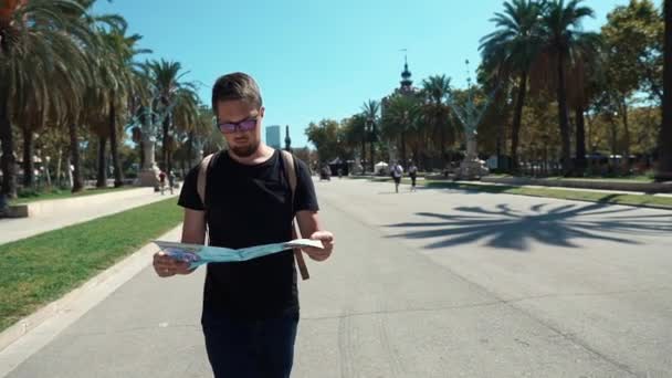 Barcelona, Spanje-September 2018. Verloren man in zwart t-shirt houden een kaart tijdens het bezoek aan de Arc de Truimf in Catalonië. — Stockvideo