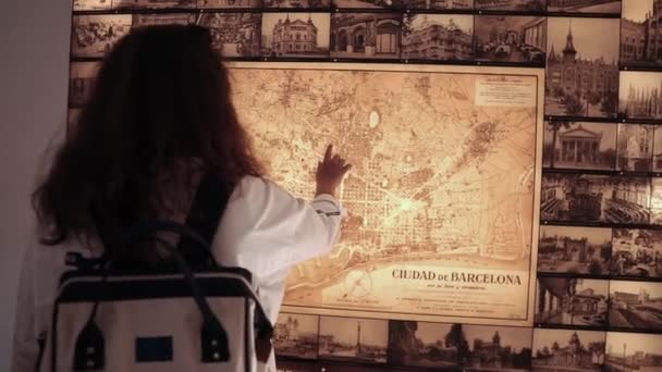 Barcelona, Spain September 2018. Shot from behind of a brunette female tourist standing by the wall map in Park Guell. — Stock Video