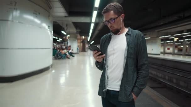 Mann mit Smartphone auf Bahnsteig in U-Bahn — Stockvideo