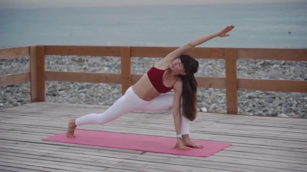 Femme d'âge moyen fait du yoga sur la plage . — Video