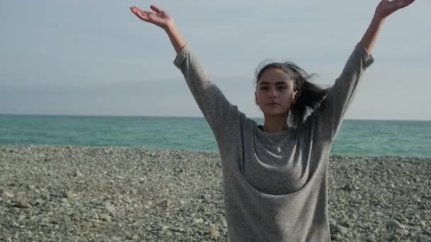 Tiener meisje is het beoefenen van yoga oefeningen in kust overdag — Stockvideo