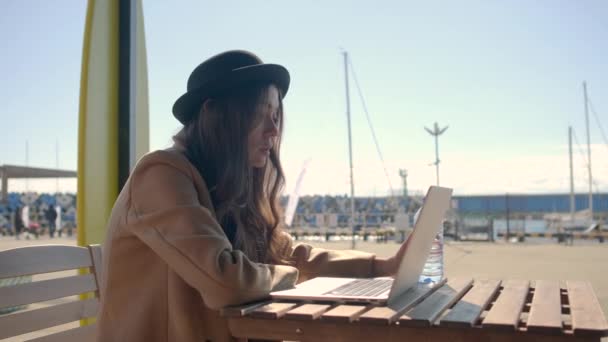 Mulher romântica está sentada sozinha na frente do laptop, vista na tela ao ar livre — Vídeo de Stock