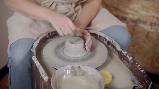 Artista donna sta modellando una tazza da pezzo di argilla sulla ruota vasaio — Video Stock