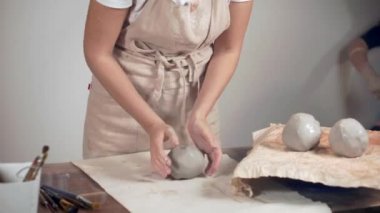 Usta heykeltıraş bez kil topları sarma ve modelleme için hazırlanıyor