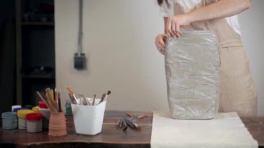 Kadın çalışma stüdyosunda modellik yapmak için balçığı açıyor.,