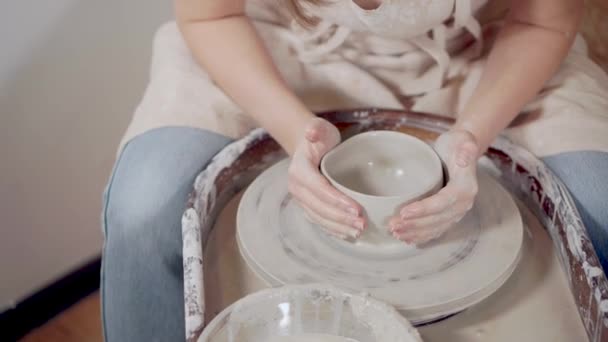 Donna ceramista sta creando ciotola di argilla con ruota vasai, primo piano — Video Stock