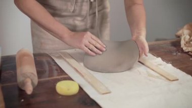 Sanatçı atölyede masaya kil unrolling, pin kullanarak, ellerin yakın çekim