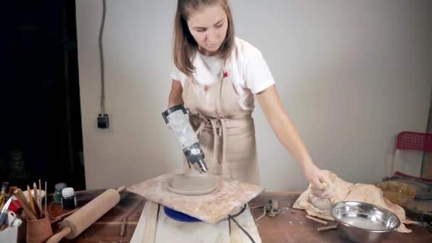 Donna vasaio sta asciugando piatto di ceramica da pistola ad aria calda in studio di ceramica — Video Stock