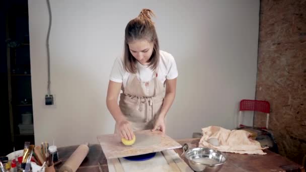 Ženská mistrička zpracovává keramickou prázdnou desku ve studiu — Stock video