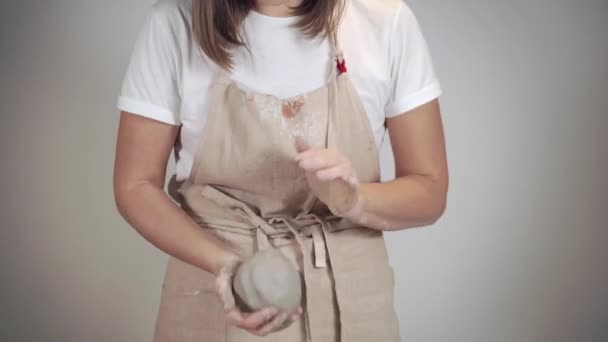 Femeia tânără frământă o bucată de lut, modelând bile, aproape de mâini , — Videoclip de stoc
