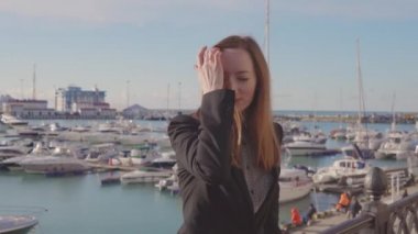 Tek başına limanda poz veren büyüleyici kadın.