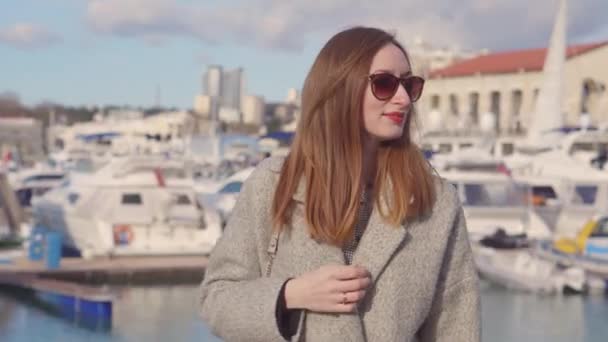 Adulte jolie rousse femme est debout dans la zone portuaire dans ensoleillé printemps jour — Video