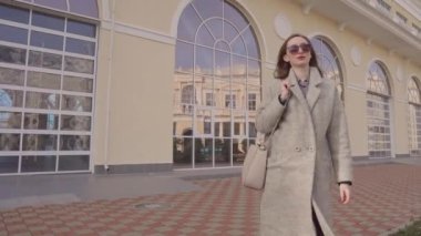 Modern gülümseyen kadın güzel giysiler içinde dışarıda yürüyüş.