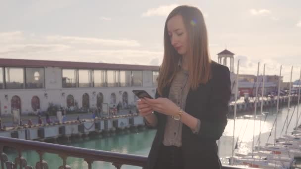 Young woman with smartphone at yacht port at spa resort. — 비디오