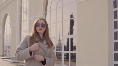 Şık bayan şehirde tek başına geziniyor, paltoya sarılıyor