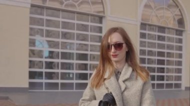 Pretty genç kadın şehirde güneşli bahar gününde yürüyerek zevk