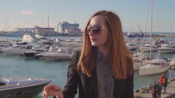 Lady élvezi kilátás kikötő mólón és Horgonyzott magán jachtok erkéllyel — Stock videók