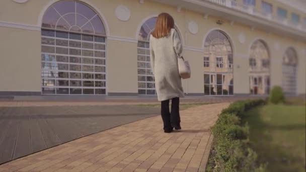 Женщина, гуляющая в парке в модной одежде . — стоковое видео