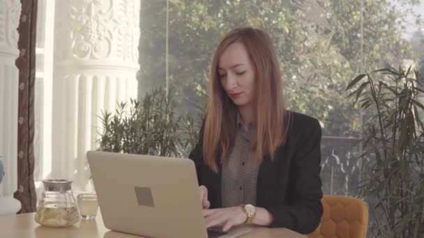 Mulher de negócios adulta está trabalhando com laptop em seu escritório, bebendo chá de gengibre — Vídeo de Stock