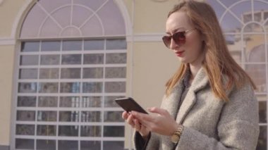 Dışarıda akıllı telefon kullanan güzel kadın.