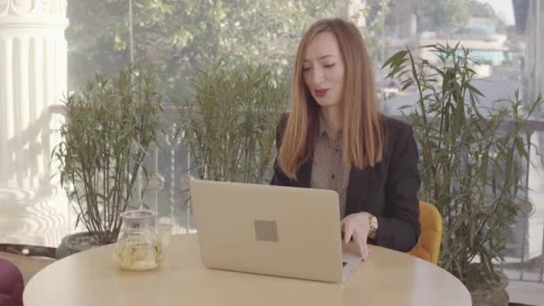 Business κυρία σε ένα καφέ με τσάι και φορητό υπολογιστή. — Αρχείο Βίντεο