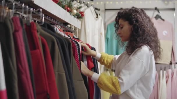 Jong meisje winkelen in een kleding winkel. — Stockvideo