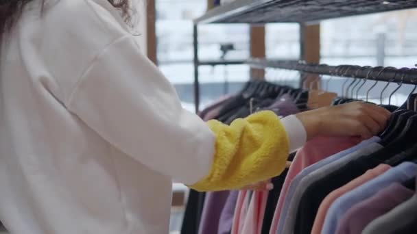 Femme cueille des vêtements dans un centre commercial . — Video