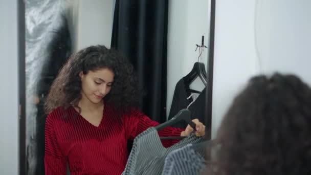 Mädchen mit zwei Kleidern in einer Garderobe. — Stockvideo