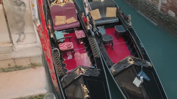 Italien, Venedig-februari, 2019: två tomma gondoler är förtöjda i smala kanalen i stan — Stockvideo