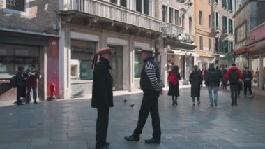 İtalya, Venedik - Şubat, 2019: Geleneksel şapkalı iki gondoliers şehirde turist bekliyor