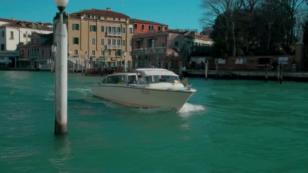 Olaszország, Velence-február, 2019: kis fehér vaporetto lebeg a csatorna a városban napsütéses időben — Stock videók
