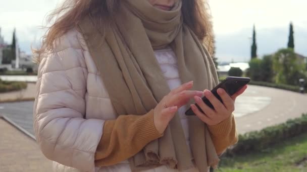 Volwassen vrouw is swipen over smartphone scherm buitenshuis op City Street, close-up — Stockvideo