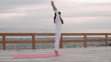Plajda yoga pratikte Fitness kadın.