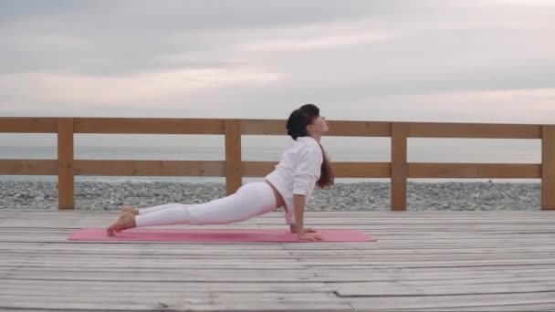 La mujer hace yoga posa afuera en la naturaleza . — Vídeos de Stock