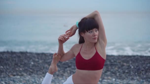Kumsalda yoga yapan bir kadın. — Stok video